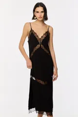 Vestido largo negro de jacquard, con tirantes finos ajustables, escote en V y falda evasé con aberturas laterales. Cuenta con apliques de encaje transparente en el busto, el centro y el bajo.