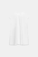Vestido corto blanco de Zara Woman Collection, confeccionado en mezcla de algodón, con cuello redondo, manga corta y diseño en línea evasé. Cuenta con bolsillos laterales ocultos y cierre trasero con cremallera.
