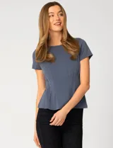 Remera blanca de manga corta con cuello redondo, confeccionada en una mezcla de modal, poliéster y elastano. Presenta un diseño con alforzas verticales en el frente que aportan estructura y una silueta relajada.
