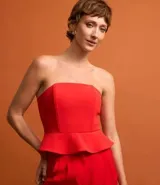 Blusa de sastrería color rojo vibrante, estilo palabra de honor con escote corazón y peplum (volado) en la cintura. La espalda cuenta con elástico para mejor ajuste y cierre trasero.