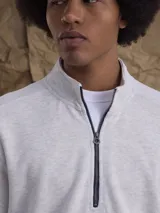 Fleece de algodón color gris melange, con cuello alto y cierre frontal parcial. Diseño de manga larga con puños y ruedo acanalados.