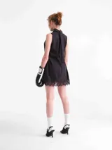 Vestido mini negro de Tencel con escote drapeado y detalle de encaje en el ruedo y aberturas laterales.