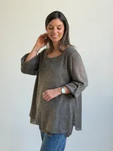 Sweater de punto color marrón chocolate, con escote redondo, mangas tres cuartos con trabilla y botón, y diseño holgado y acampanado.