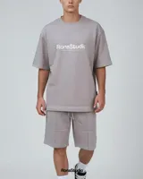 Conjunto de dos piezas compuesto por remera de corte oversize y bermuda a juego, confeccionado en algodón premium de alto gramaje. La remera presenta cuello redondo y estampado frontal con efecto desgastado, mientras que la bermuda cuenta con cintura elástica con cordón ajustable y diseño minimalista.