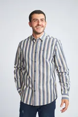 Camisa de hombre de corte slim, con diseño de rayas verticales en tonos azul, blanco y beige. Presenta cuello clásico, cierre frontal abotonado y logo bordado en el pecho.