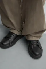 Zapatilla de cordones monocolor blanca, con parte superior fabricada en combinación de piezas, horma redonda y suela con volumen.