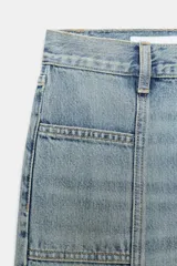 Jeans de tiro alto color azul claro, con bolsillos delanteros y traseros, y detalle de costura vertical en el frente. Cierre frontal con cremallera y botón metálico.