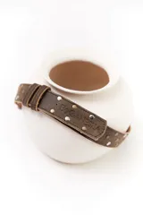 Cinturón negro de cuero con apliques de pelo animal print y hebilla metálica con el logo de la marca.