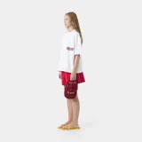 Remera oversized de algodón blanca, de manga corta y cuello redondo, con estampado gráfico multicolor en la espalda.