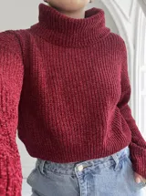 Sweater de punto grueso color bordó, con cuello alto y mangas largas.