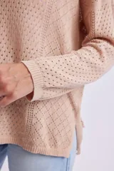 Buzo de punto fantasía color beige con diseño calado, escote redondo y mangas largas.