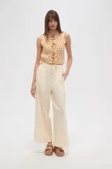 Pantalon de corte recto y tiro alto, confeccionado en viscosa de color natural, con cintura elástica y cordón ajustable.