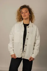 Camisa de denim blanca, estilo overshirt, con bolsillos frontales con solapa y cierre de botones metálicos.