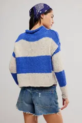 Sweater de punto grueso a rayas anchas azules y beige, de calce corto y amplio, con cuello alto vuelto y mangas caídas.