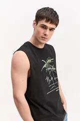 Musculosa oversize blanca de algodón, con sisas amplias y estampa frontal de inspiración tropical con palmeras y texto.