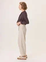Pantalon de corte recto y tiro medio, confeccionado en tejido de lana con sutiles rayas verticales. Presenta bolsillos traseros aplicados, costuras reforzadas en las rodillas y ruedo con dobladillo.