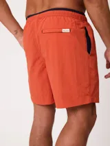 Short de baño Polanco modelo Loraz, color coral, con cintura elástica, cordón ajustable blanco y negro, bolsillos laterales y pequeño logo circular estampado en la pierna.