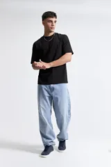 Remera de manga corta con corte boxy, cuello redondo y hombros caídos. Confeccionada en algodón, presenta un diseño holgado y recto.