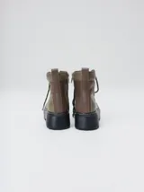 Botas de cuero estilo trekking, en combinación de colores verde, marrón y gris, con plataforma de goma negra, cordones bicolor inspirados en cuerdas de escalada y pasadores en tono rojizo.