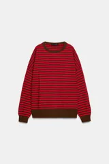 Jersey de punto con diseño a rayas horizontales en color rojo y marrón. Presenta cuello redondo, manga larga con puños ajustados y ruedo acanalado.