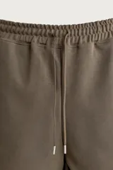 Bermuda estilo jogger de ajuste relajado, confeccionada en tejido interlock de algodón. Cuenta con cintura elástica ajustable con cordón, bolsillos frontales de vivo y diseño liso.