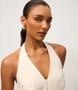 Blusa sastrera color marfil de corte halter con escote en V, cierre frontal con ganchos y bolsillos ribeteados simulados.
