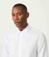 Camisa blanca de algodón, corte slim fit, manga larga y cuello clásico.