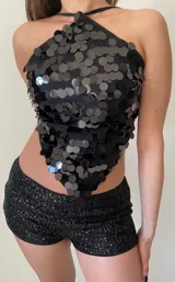 Top de escote halter con diseño triangular, completamente cubierto de lentejuelas circulares negras brillantes.