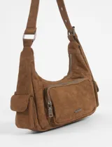 Cartera de hombro color rojo, confeccionada en símil gamuza, con diseño de múltiples bolsillos externos, incluyendo uno frontal con cierre y dos laterales. Cuenta con correa ajustable y logo metálico de la marca en el frente.