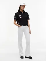 Chomba negra de algodón elástico con cuello polo, cartera de dos botones y mangas cortas. Presenta detalles de ribetes con diseño Global Stripe en el cuello y los puños, además de los logotipos de Tommy Hilfiger, TH x Cadillac Formula 1 Team, Pirelli y el número 11 en las mangas y el pecho.