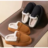 Pantuflas sin talón de gamuza marrón, con interior de corderito sintético, suela plataforma y tira ajustable con hebilla en el empeine.