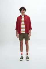 Camisa de manga larga color rojo ladrillo, con cuello clásico, cierre frontal con botones y bolsillo en el pecho.