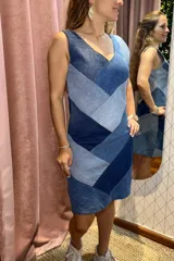Vestido corto sin mangas con escote en V, confeccionado en denim con un diseño de patchwork en diferentes tonos de azul. Presenta un corte recto y favorecedor.