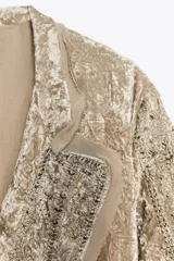 Kimono de terciopelo con cuello solapa y manga larga. Presenta bordados a tono en toda la prenda, cinturón ajustable del mismo tejido y acabados desflecados. Incluye forro interior.