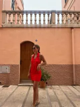 Vestido corto rojo con cuello polo, cierre frontal con cremallera y diseño calado.