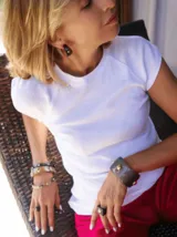 Par de argollas de asta color negro con diseño de media luna y detalle de perla blanca en el centro.