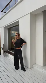 Pantalón negro de algodón y viscosa, con estampado de lunares blancos y corte holgado.