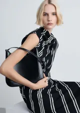Vestido midi de diseño asimétrico con estampado de rayas verticales blancas sobre fondo negro. Presenta cuello perkins, mangas cortas y tejido fluido con acabado satinado.
