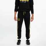 Pantalón de jogging negro con puños elásticos, cordón ajustable en la cintura, escudo del Club Atlético Peñarol bordado en amarillo y franjas laterales amarillas y grises.