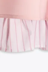 Vestido corto color rosado pálido, con escote cuadrado y tirantes finos ajustables. El bajo tiene un forro con volado de tela a rayas verticales blancas y rosadas.