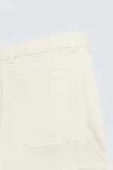 Bermuda relaxed fit confeccionada en tejido de algodón con efecto lavado. Presenta un diseño de cinco bolsillos, bolsillo multifunción en la pernera y tira lateral de estilo carpintero. Cuenta con cierre frontal con cremallera y botón.