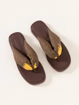 Sandalia marrón con base de goma y tira de tela estampada con diseño de palmeras.