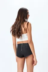 Microshort de tiro bajo color negro, con cierre metálico en la espalda, de calce ajustado y largo mini.