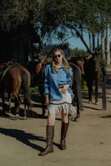 Minifalda color crema de cuero ovino con flecos y detalles en cuero marrón. Cierre frontal con cremallera. Estilo country.