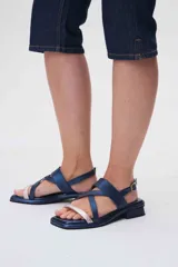 Sandalias de cuero azul con tiras cruzadas y hebilla lateral. Presenta una tira delantera color rosa claro.