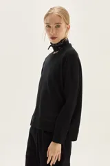 Sweater de tejido de punto color crudo, con escote redondo y mangas largas con puños acanalados. Presenta un calce cómodo y holgado.