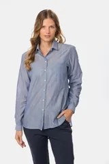 Camisa celeste con rayas verticales blancas, de corte holgado y manga larga.