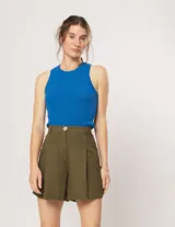 Short color beige de lino con tiro alto, elástico en la pretina trasera, cierre delantero con botón, tablas en el frente, bolsillos delanteros y dobladillo invisible.