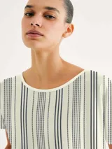 Blusa de manga corta con cuello redondo y estampado de cuadrícula blanca sobre fondo color tostado.