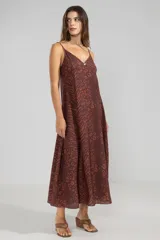 Vestido largo hasta el tobillo color marrón con estampado animal, breteles finos y escote en V profundo con detalle de flor.